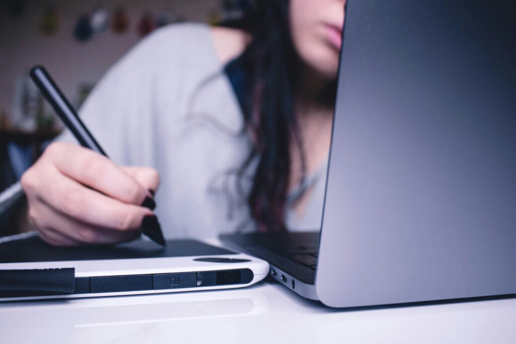 Mulher branca em frente a notebook estrutura estratégias para reduzir inadimplência.