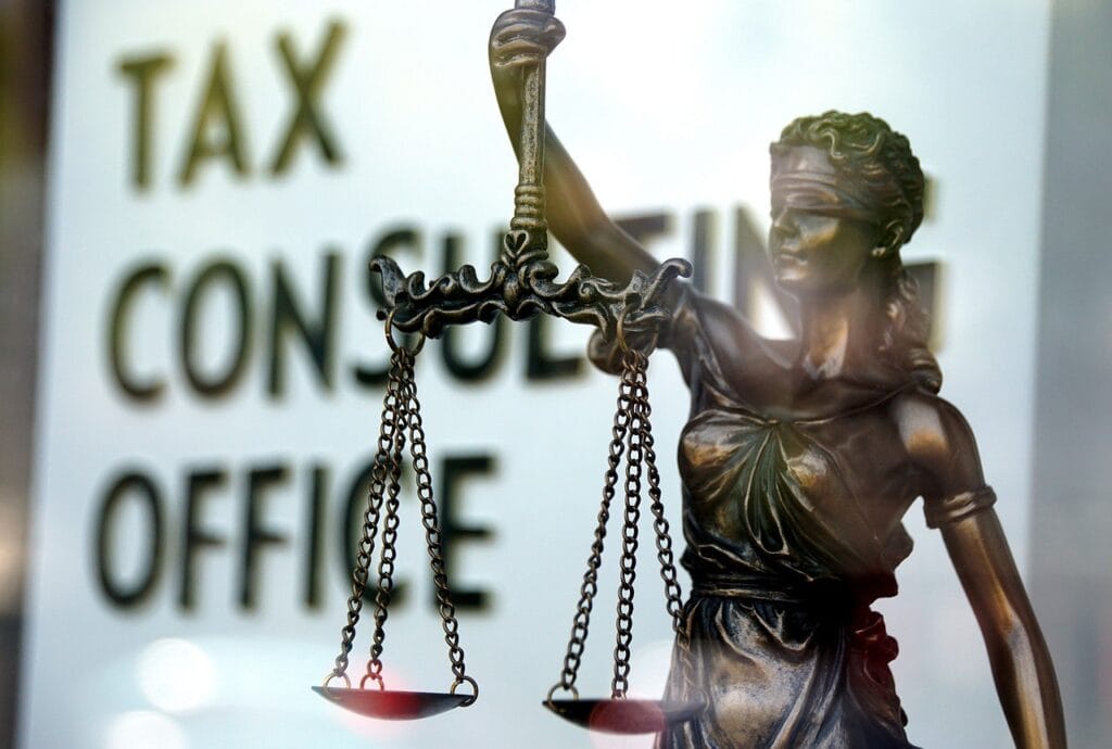 Estátua da justiça representa restituição de impostos como um direito.